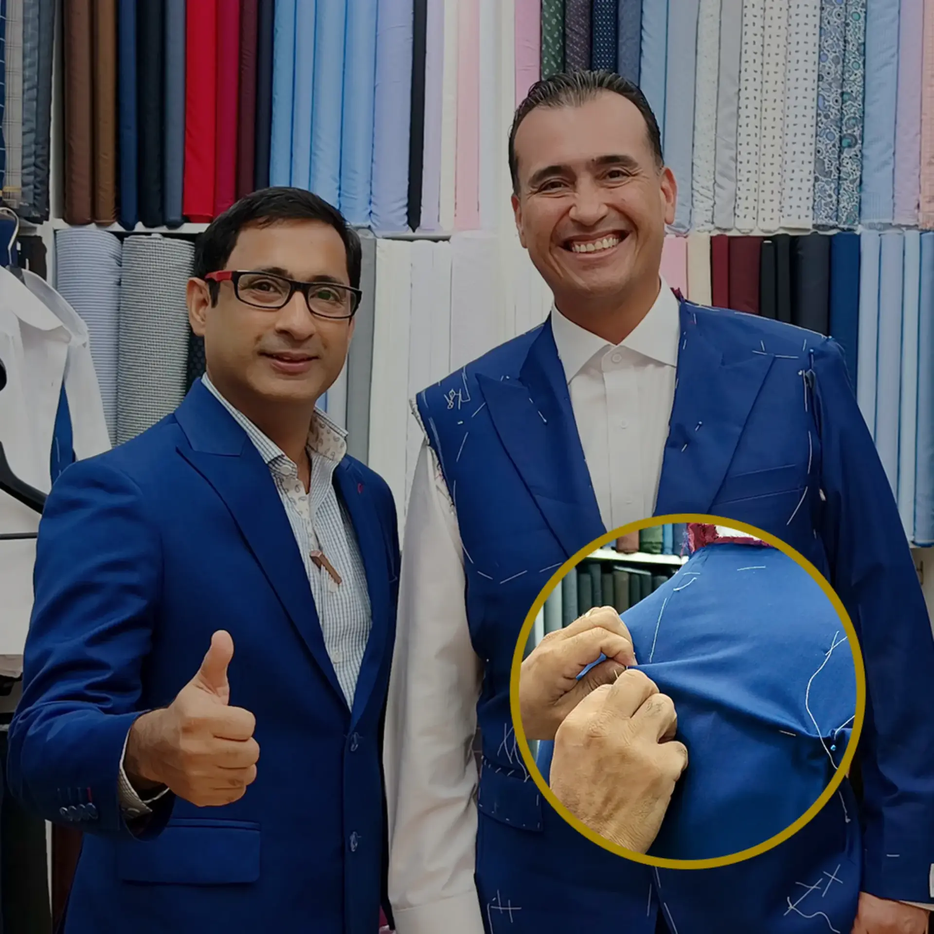 Two men in royal blue suits in front of the fabric wall, with a close-up of hand stitching on the cloth