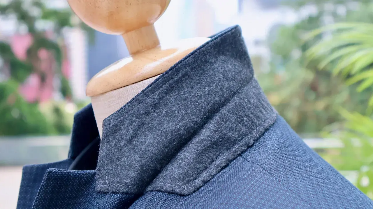 Textured blue bespoke jacket with a grey felt under-collar on a mannequin
